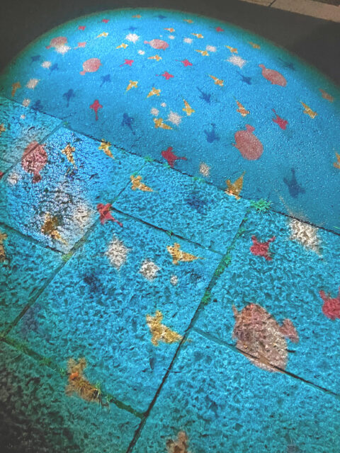 地面に投影された魚たちの光の演出